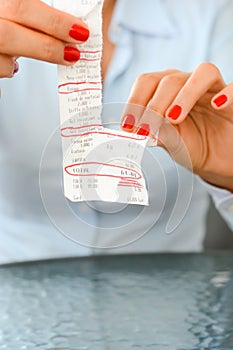 Daily expenses concept with woman tossing a paper fiscal receipt